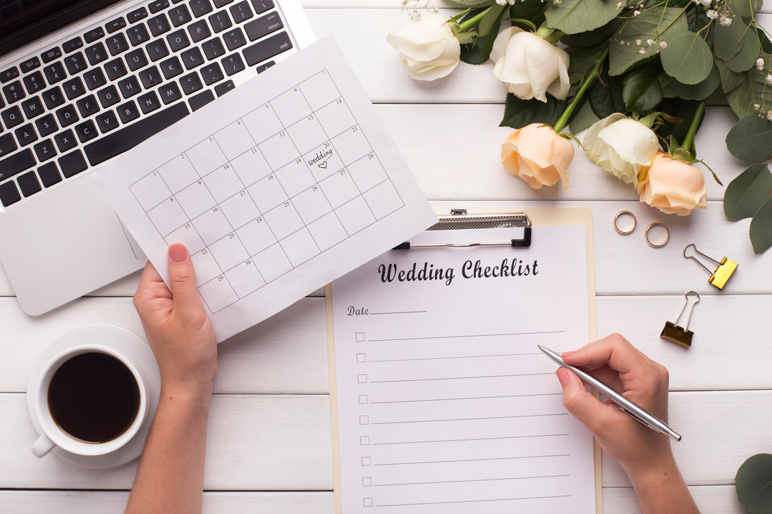 Bride Planning wedding writing checklist and choosing date in calendar